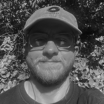 Arlie, in a red cap and glasses, looking at the camera