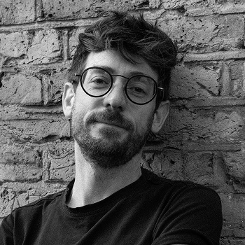 Adam Zmith, with arms stretched, smiling gently at the camera