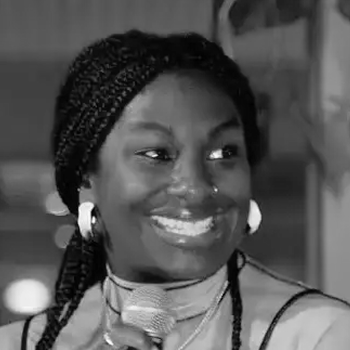 Abi on a panel discussion, holding a mic and smiling