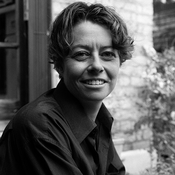 Tash Walker, with short hair, smiling gently at the camera